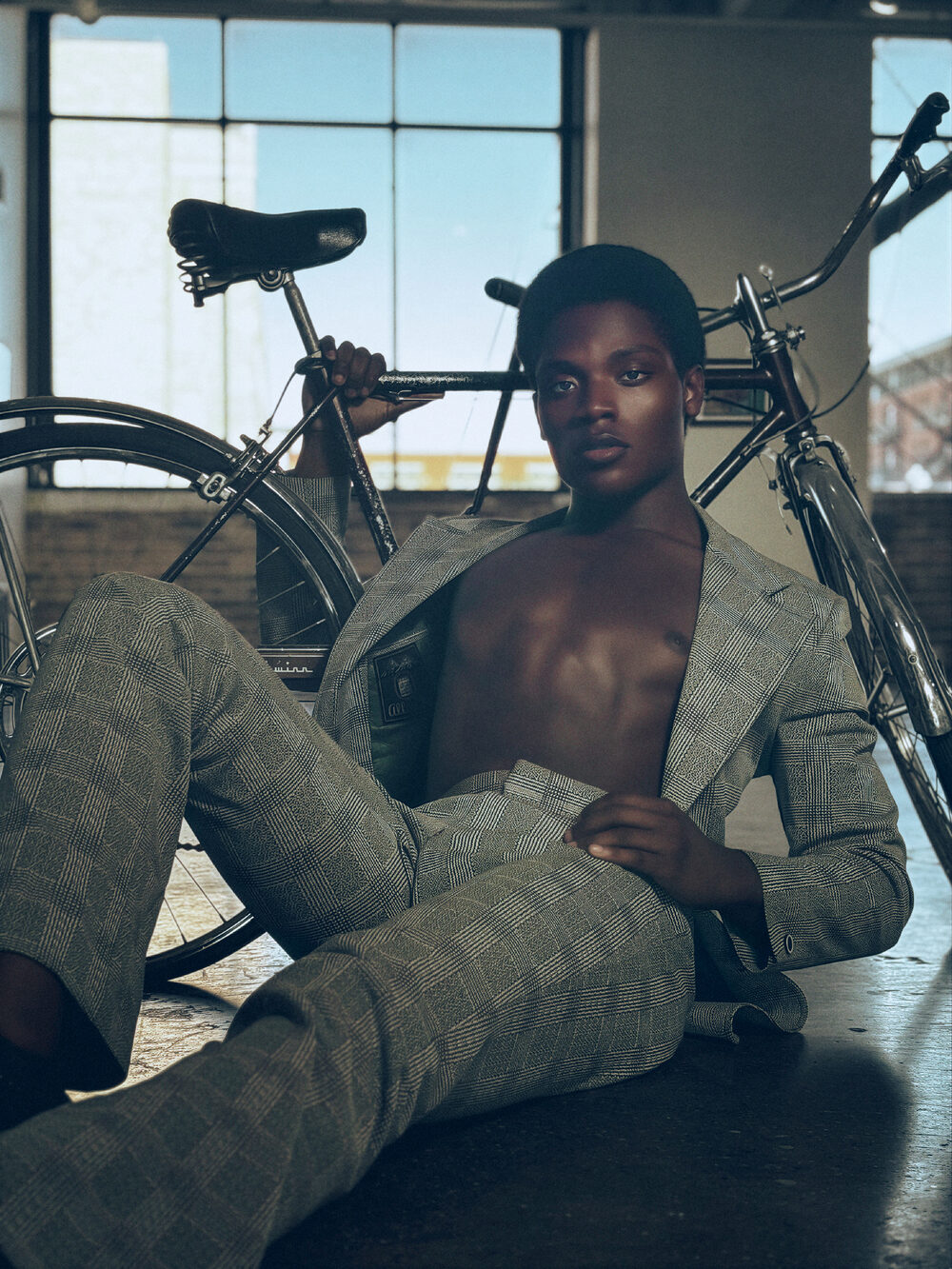 Editorial fashion portrait with bicycle, plaid suiting